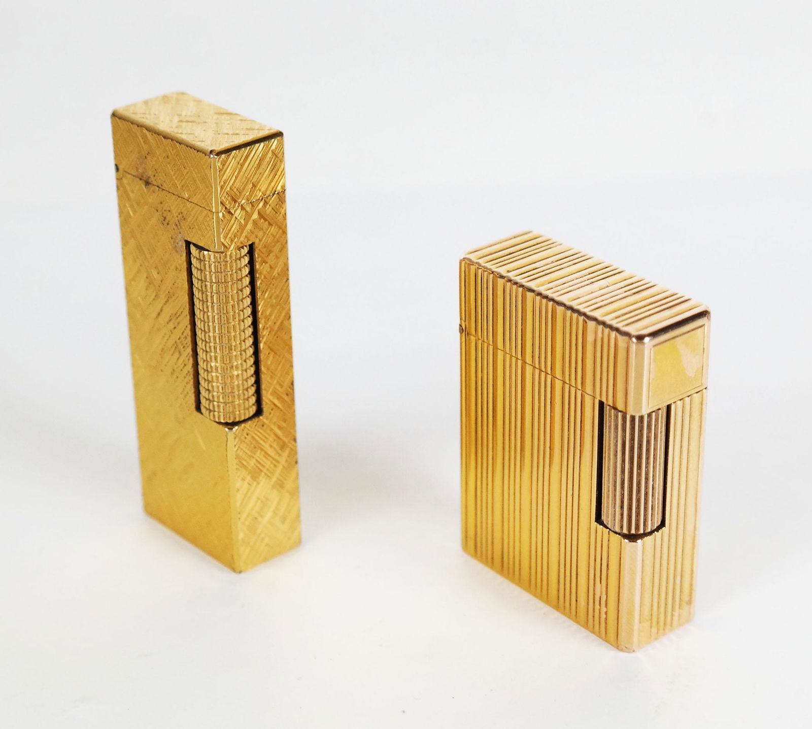 Two Gold Plated Lighters: Two gold plated lighters, including one Swiss Dunhill [2 1/2" H x 1" W], and one French Durmont [2" H x 1 1/2" W].
