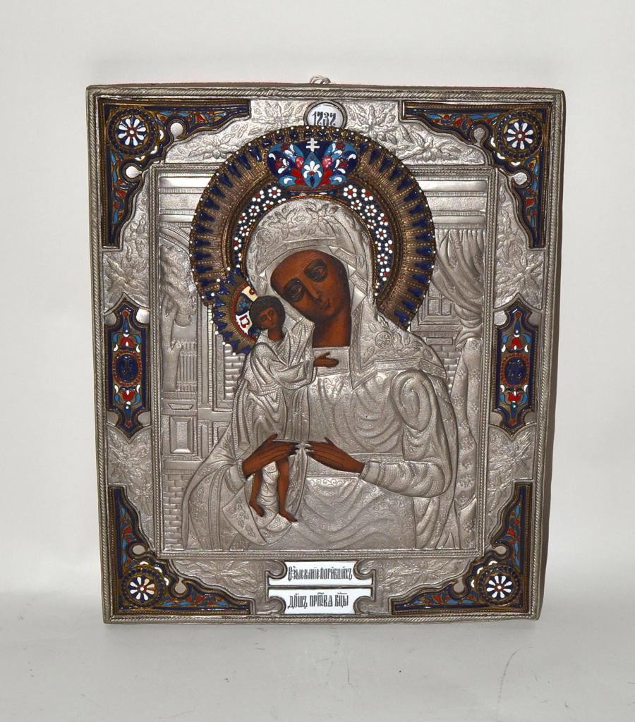 Silver Russian Icon - Madonna & Child: Russian icon featuring a chased and repousse silver cover, each figure bears a gilt brass halo with colorful champleve enamel. 12.25" x 9.75". Minor surface abrasions, otherwise in very good condition
