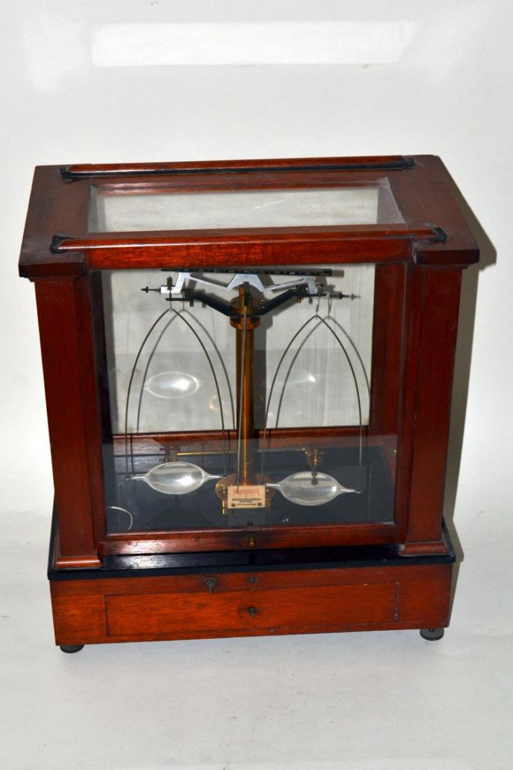 Balance Scale by Seederer-Kohl Bush: Analytical balance scale with four sided glass and mahogany case, leveling feet, brass beam, and nickel pans. 16 5/8" x 9 5/8" x 18 3/8". Missing two knobs, otherwise good condition.