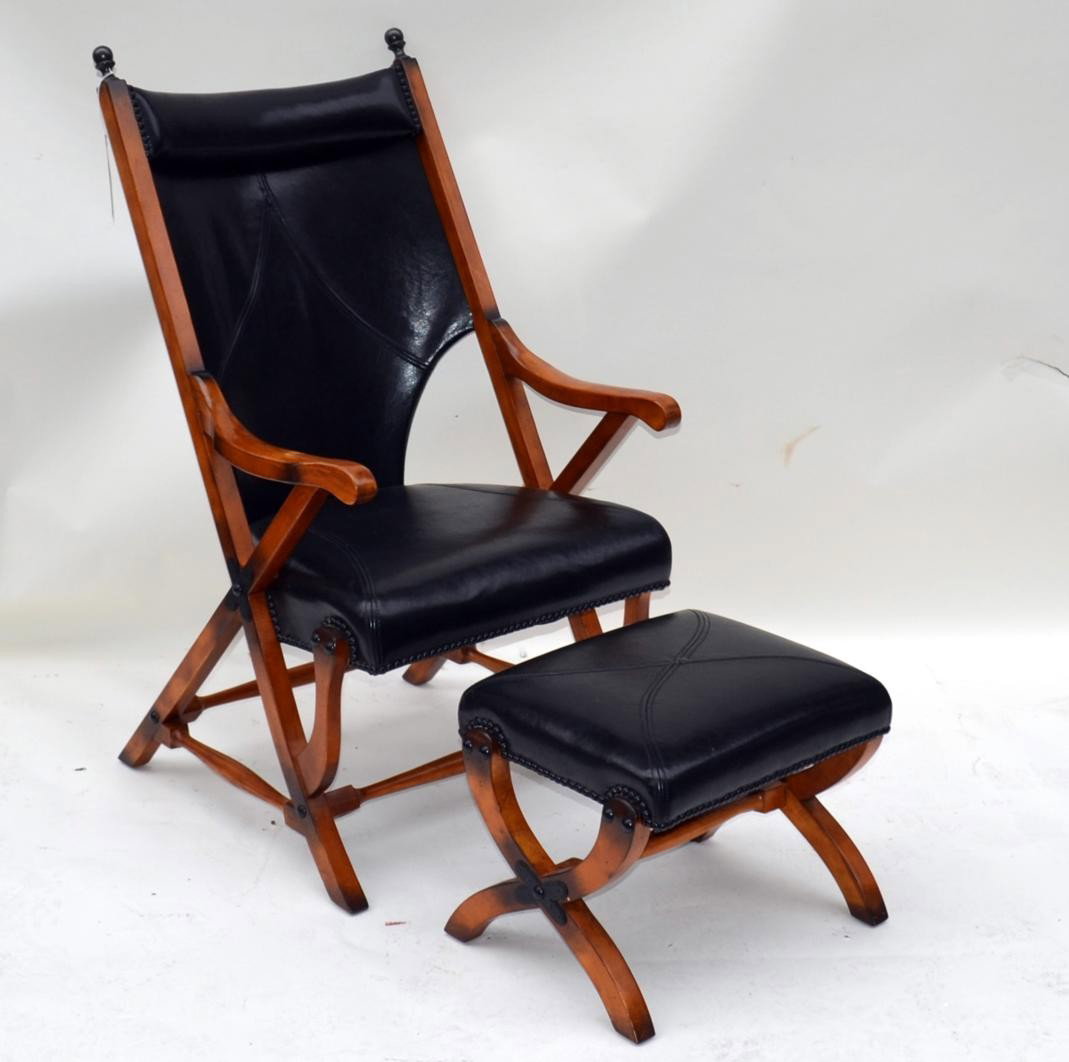 Campaign Style Chair and Bench: Having a maple burnished wood frame and matching X-form ottoman. Upholstered in black leather. Chair: 25"x27.25"x43", Ottoman: 19.25"x15"x15"