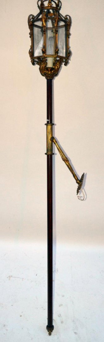 Torch Form Wall Sconce: Having an octagonal bronze lantern with a crown atop, on a rosewood pole., with a bronze base and bronze collar. With drapery form mounting hardware. 76" H