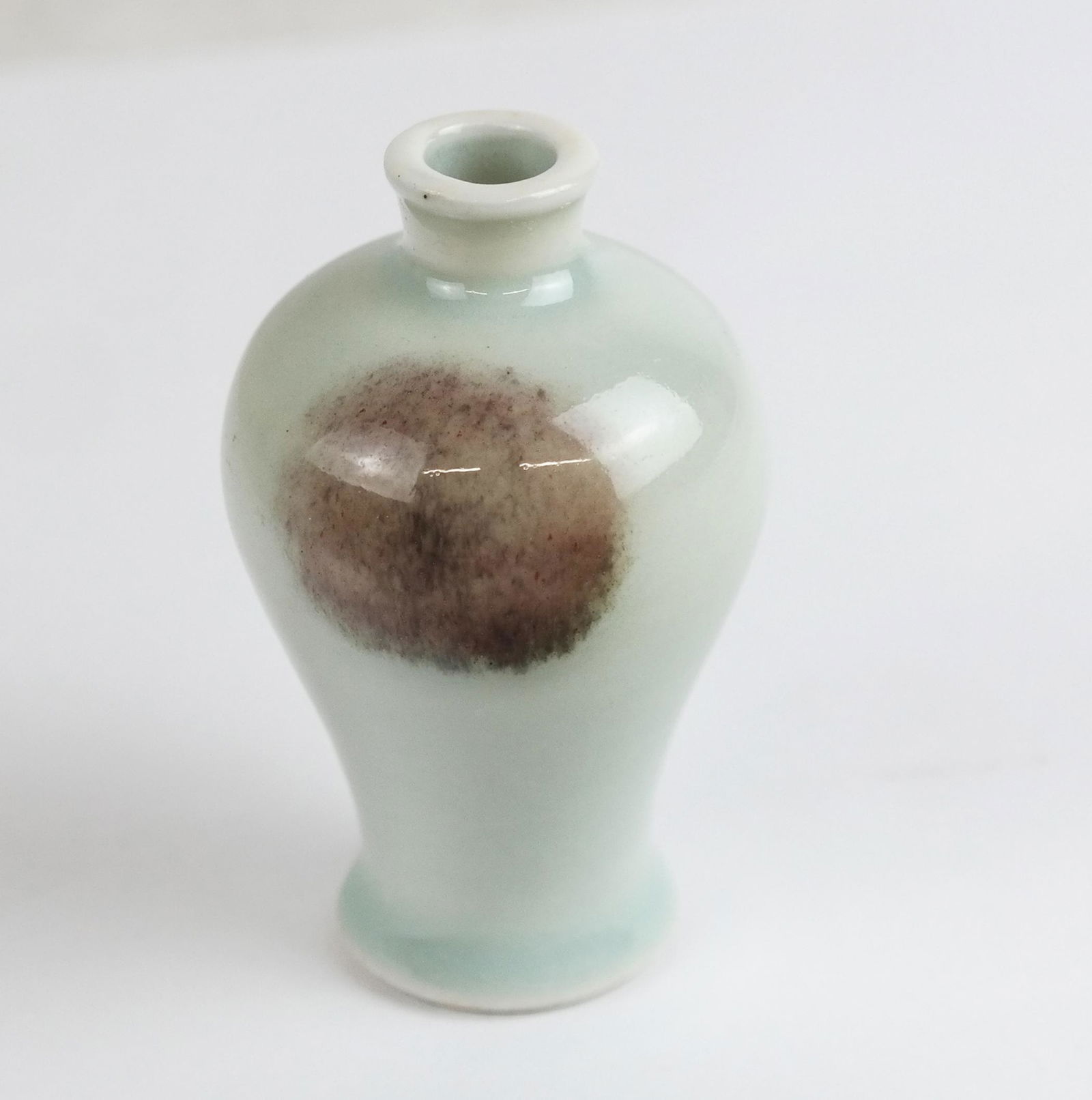 Small Celadon Mi Ping Form Porcelain Vase: Small celadon Mi Ping form porcelain vase with single circular detail decoration; unmarked. [2 1/2" H x 1 1/2" W]. In good condition.