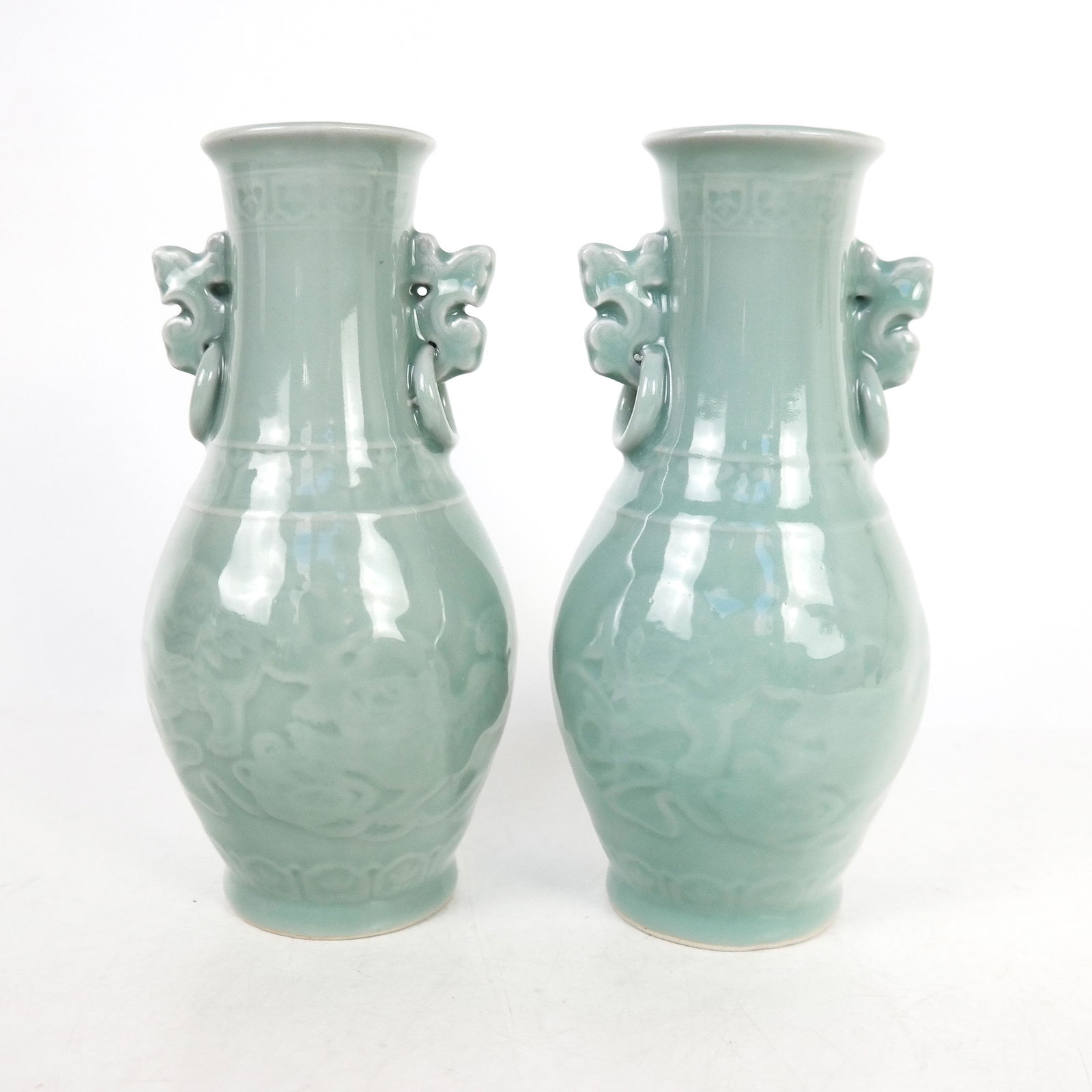 Pair of Chinese Celadon Vases: Pair of pale green Chinese vases with surmounts. [8 1/4" H]. In good condition.