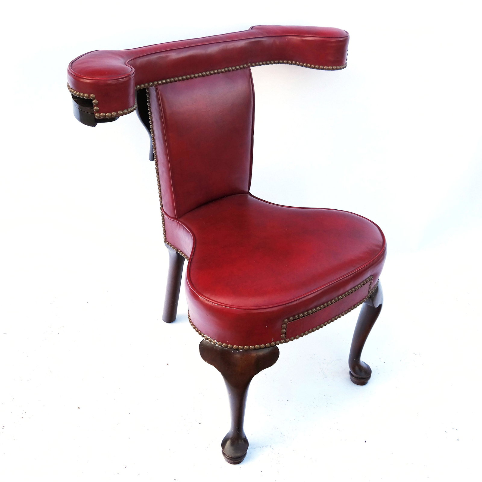 Antique Mahogany Cockfight Chair: Red upholstered, nail head trimmed cockfight / voyeuse chair with a table back, having pull-out holders on arms. [33" H x 30" W x 24" D]. In good condition. At 150 pratt