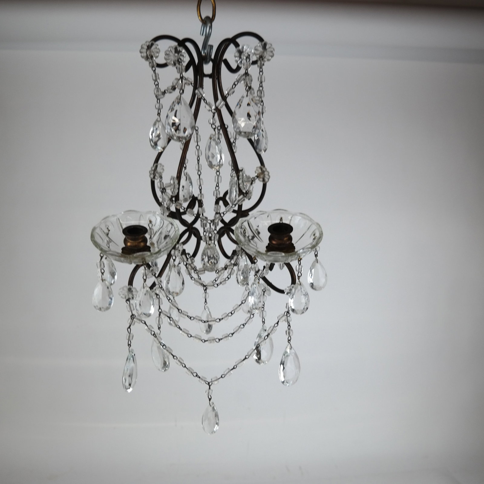 Pair of Glass & Metal Wall Sconces: Pair of glass and metal wall sconces, of skeletal form, with attached rosette, having bead and prism glass decoration. Not electrified. [17" H x 10 1/2" W x 7 1/4" D]. In good condition.