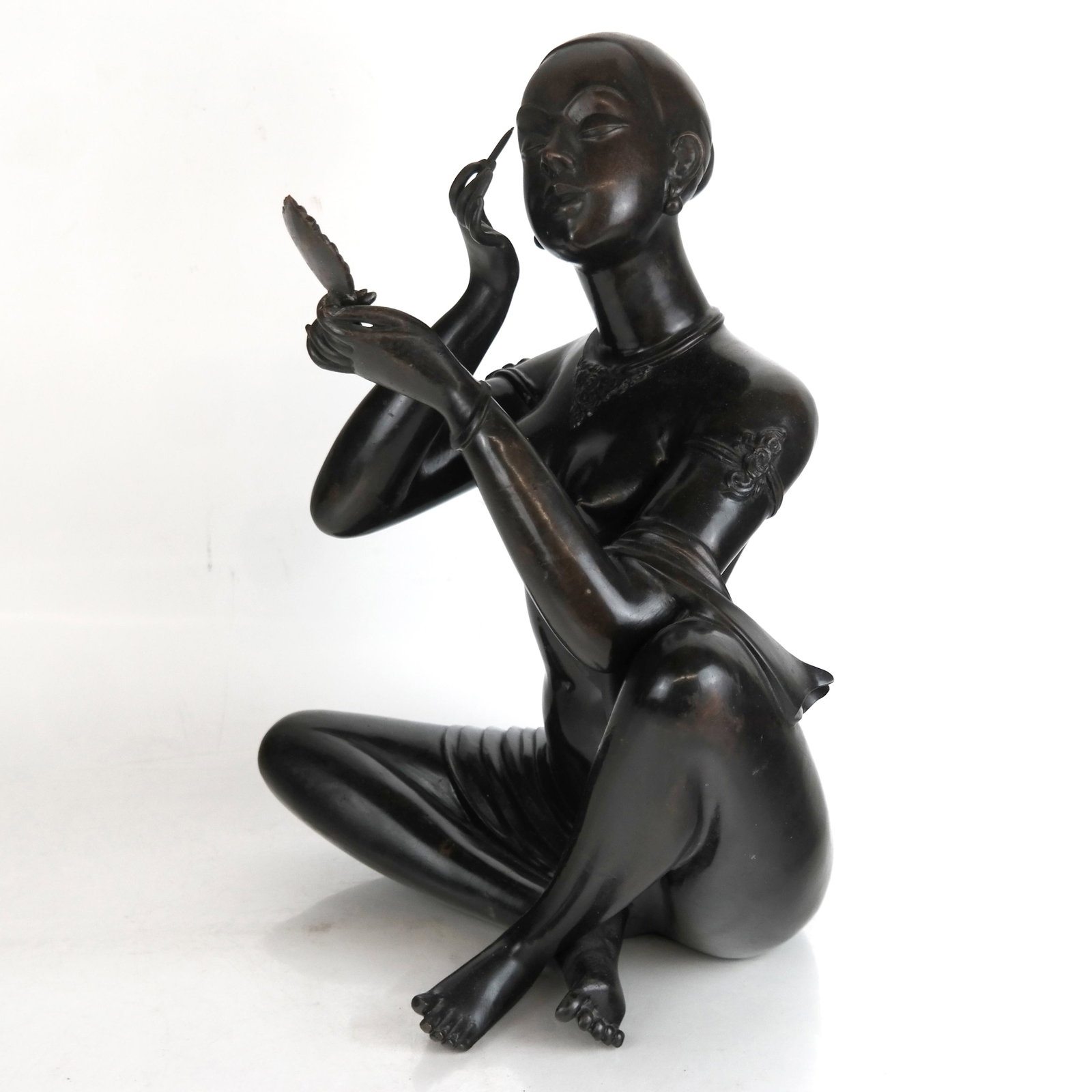 20th Century Bronze Sculpture of Woman with Mirror: 20th century bronze sculpture modeled as a woman applying makeup, partially clad with drape and jewels; not signed or marked. [16 3/4" H x 12 1/2" W]. Mirror separate. Minor imperfections to bronze pa