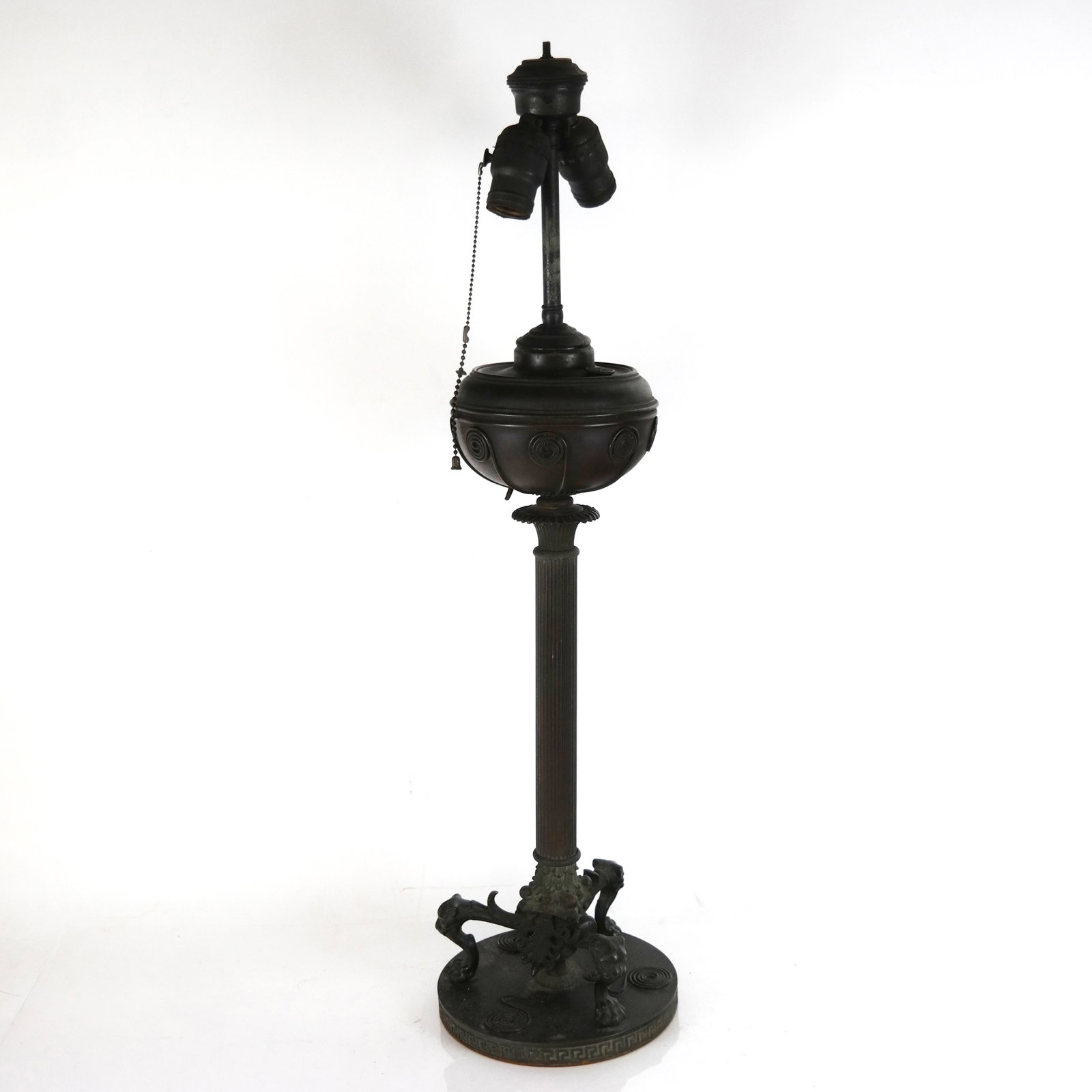 Antique B&H Greek-Style Columnar Lamp: Antique Greek-style columnar lamp with bronze patina, attributed to Bradley and Hubbard, on tripod base with lion mask and claw feet; electrified. [29 1/4" H x 7 1/2" W]. Lacking flex. Aged condition,