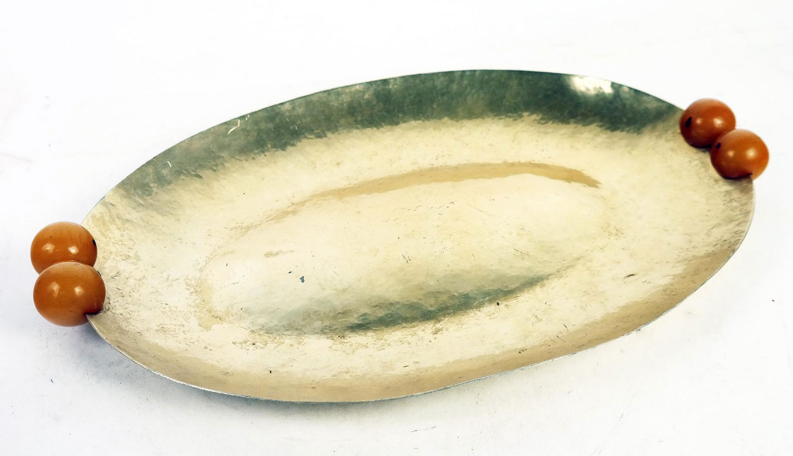 Mid-Century Modern Hammered Gilt Metal Tray: Mid-century modern gilt metal tray with Bakelite ball handles, unsigned. [2 1/2" H x 18" W x 11 1/2" D]. Scratches and wear to finish.