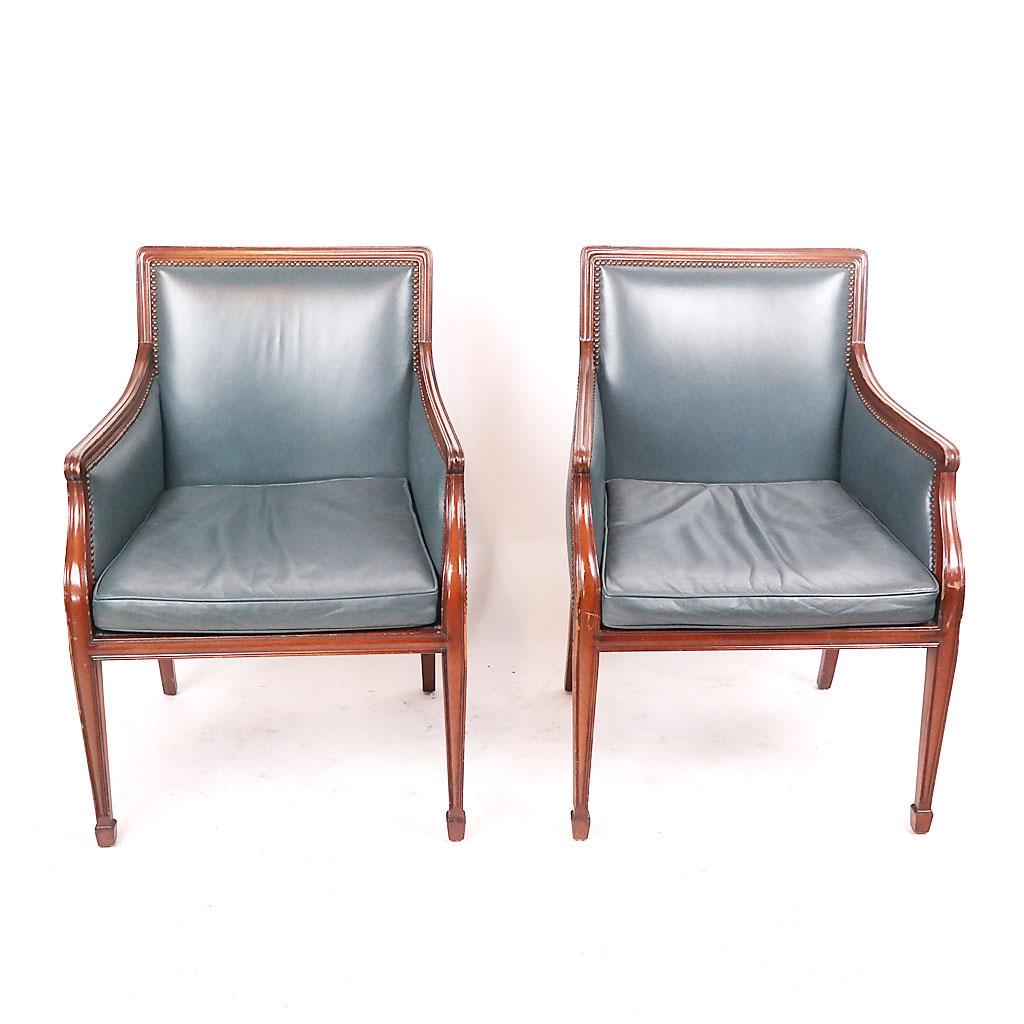 Smith & Watson NY Pair of Armchairs: Pair of carved mahogany armchairs, by Smith & Watson NY, in blue leather with pad seats, with studded trim. [36" H x 25" W x 27" D].