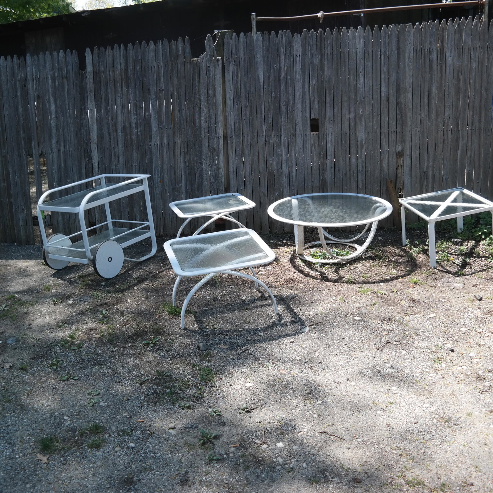 Suite of Garden Patio Furniture by Brown Jordan: Suite of garden furniture, comprising four tables and a trolley. [Tables: 25" W x 25" D; 22" W x 22" D; Trolley: 26" H x 32" W x 22" D; Circular table: 39" Diam.]. Soiled, otherwise in good condition.