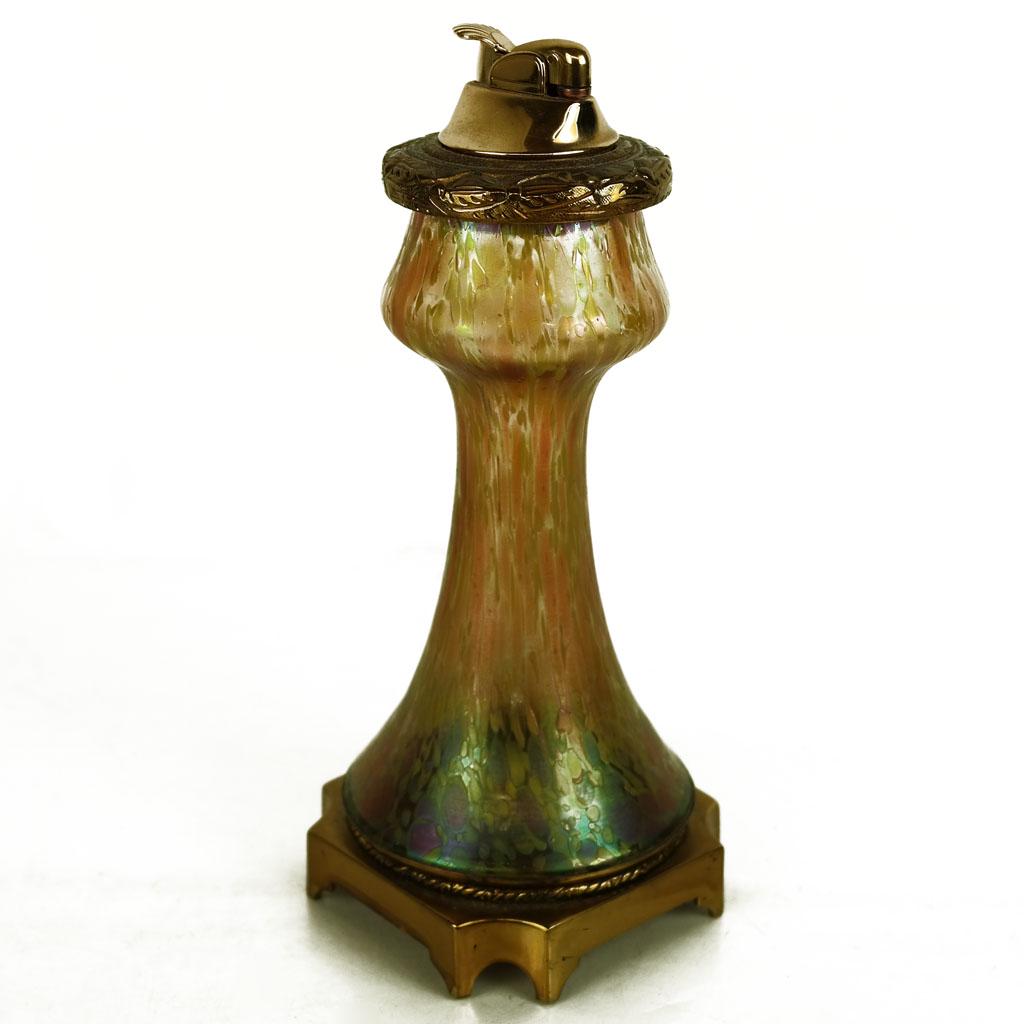 French Gilt Metal-Mounted Glass Lighter: Early 20th century French gilt metal-mounted glass lighter, with Neoclassical details around the favrile glass body with Murano-style decoration, marked to base "Made in France". [8 3/4" H x 3 1/2" W 
