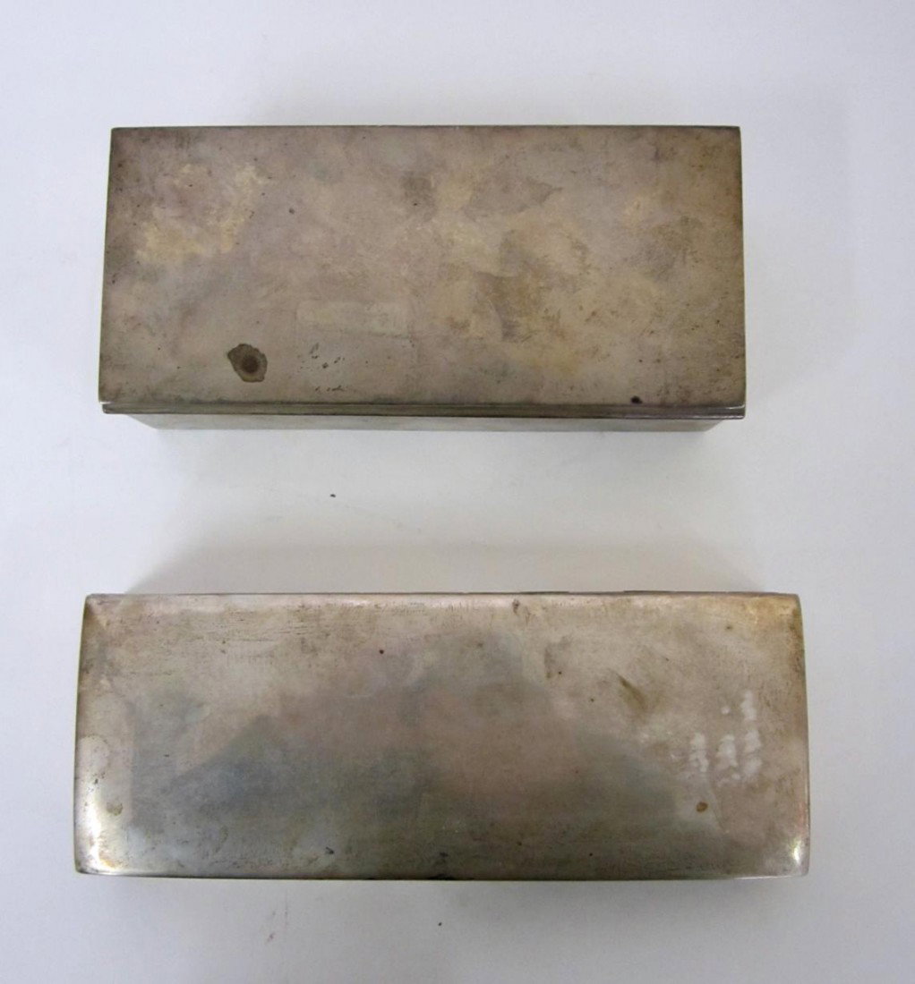 Two Sterling Silver Cigarette Boxes: Comprises a box [7 1/2" W x 3 1/2" D x 2 1/4" H] with engraved inscription on inside lid and two wood compartments accompanied by a box [8 1/2" W x 3 1/4" D x 1 5/8" H]. Bears wood liner.