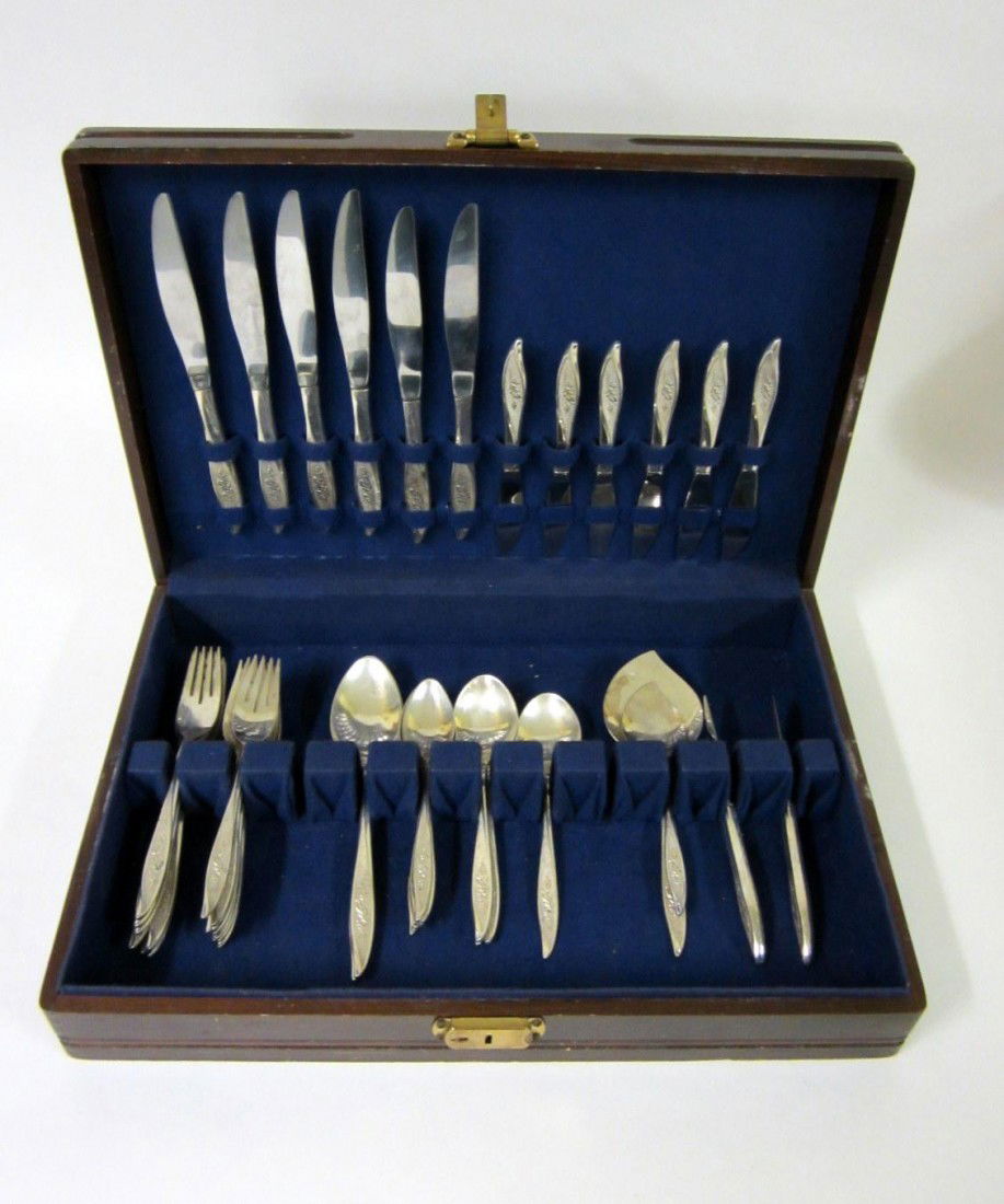 44 Pieces of Sterling Oneida Flatware: Heirloom pattern comprising: 4 soup spoons, 6 teaspoons, 7 salad forks, 9 dinner forks, cream spoon, straining spoon, 2 slices, 8 butter knives, 6 dinner knives. [39.97 ozt]