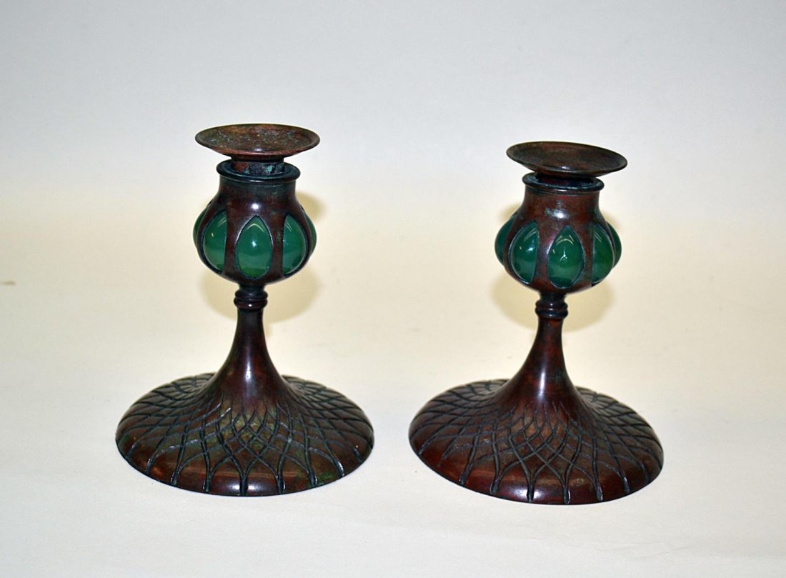 Pair of Tiffany Studios Candlesticks: Tiffany Studios favrile glass and patinated bronze candlesticks. Base with incised lattice and mottled redish-brown patina. Stamped "TIFFANY STUDIOS/NEW YORK". 5 3/4"H x 2 7/8"Dia. (base)
