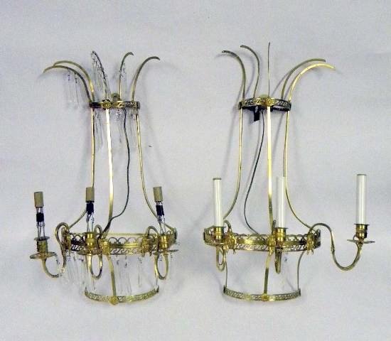Pair of Gilt Metal Three-Light Wall Sconces: A pair of neo-classical style gilt metal three-light wall sconces with crystal drops; electrified. Some wear and losses to crystals. 21" x 14".