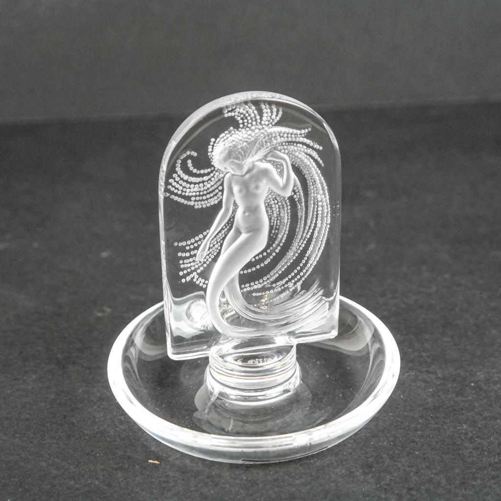 Lalique French "Naiade" Trinket Dish: Lalique French glass "Naiade" trinket dish with stylized nude figure, bearing etched signature to base. [4 1/4" H x 3 7/8" Diam.]. Light abrasions, stickers and adhesive residue to base.
