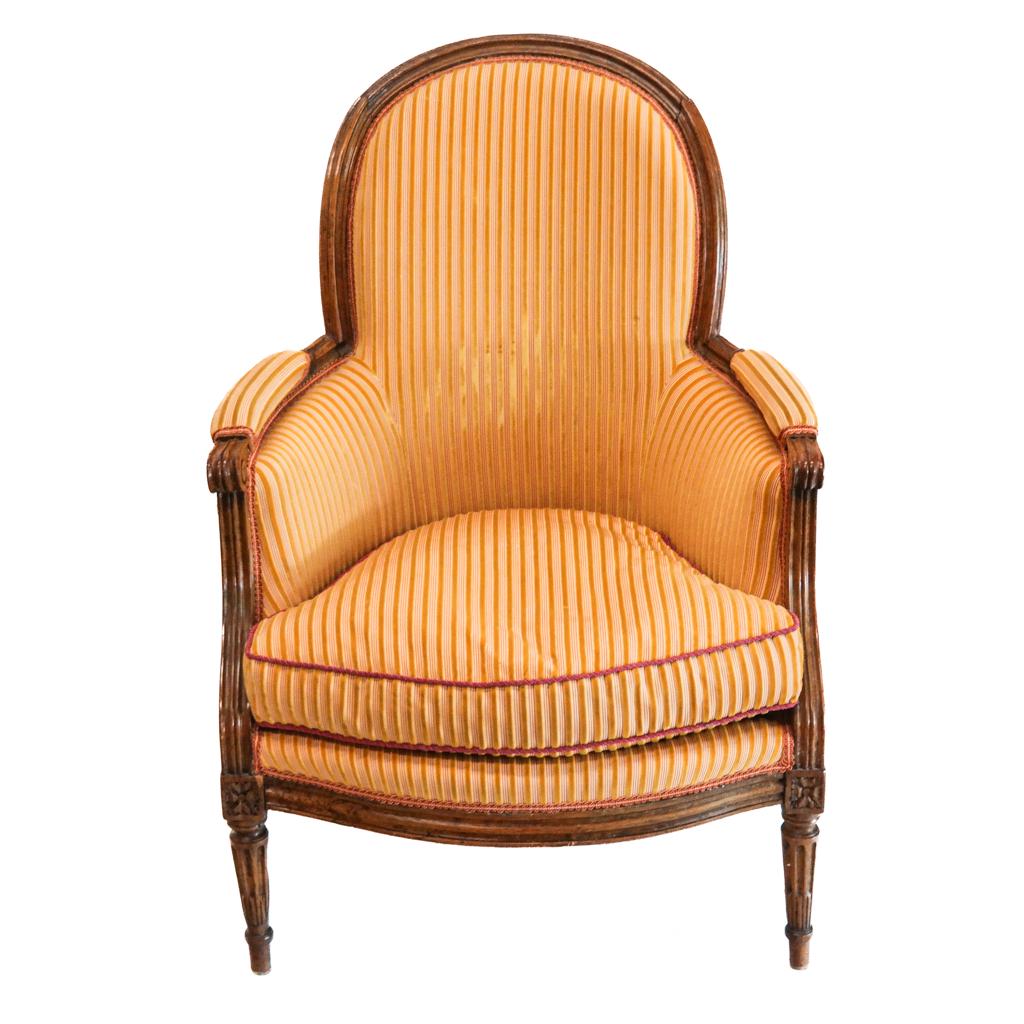 Louis XV/XVI-Style Carved Bergere: Louis XV/XVI-style carved bergere, the armchair with velvet and striped fabric. [37" H x 26" W x 27" D]. Light marks and wear.