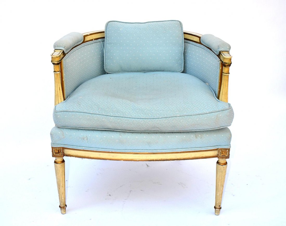 French Style Bergere: Louis XVI style painted and decorated bergere, reed form columns, caned backs and rosette decor, in blue upholstery.