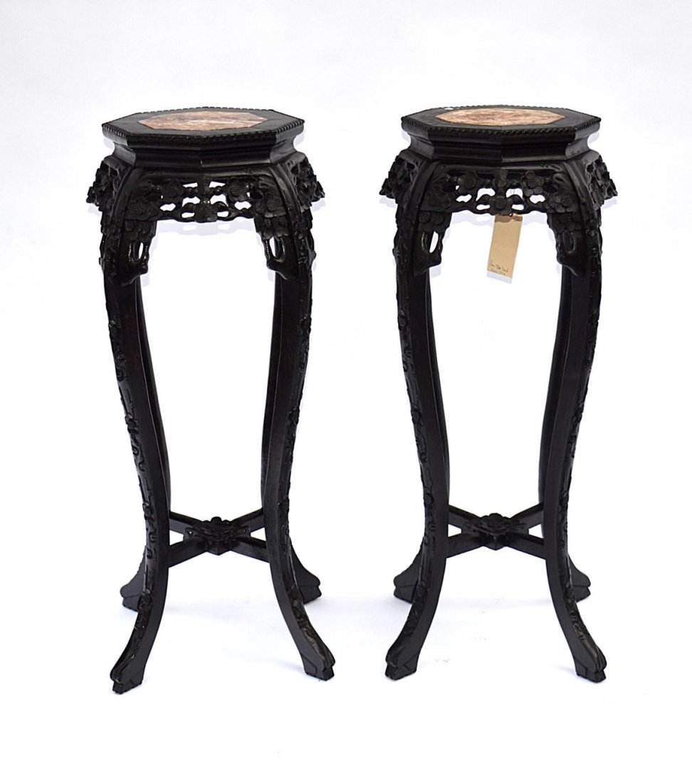 Pair of Chinese Octagonal Marble Top Stands: Carved and ebonized wood stand with cabriole legs, cross-stretcher, and pierced apron, all with floral motif. 17 1/4" Dia x 36 1/2" H. In good condition.