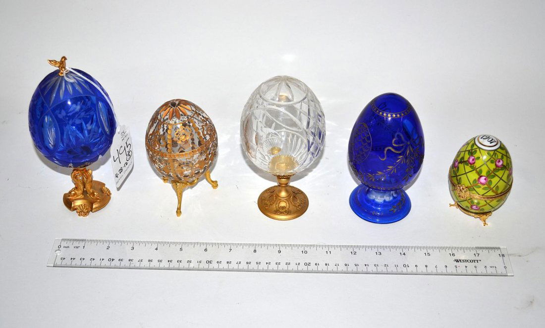After Faberge Decorative Egg Group: Comprises clear and blue glass wheel cut eggs, some with bronze dore bases and gilt accents. Includes a hand painted porcelain egg inscribed "1907" on top. Tallest: 7 1/4" H, Shortest: 4" H. In good c