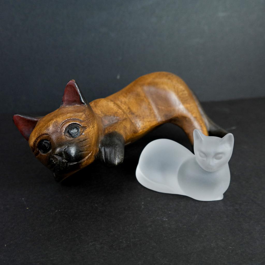 Glass & Carved Wood Cat Models: Two model cats, one in glass by Lenox, signed, the larger in wood, carved to stay on a shelf, of Thailand manufacture. [Larger: 5" H x 8" W x 3 1/2" D]. In