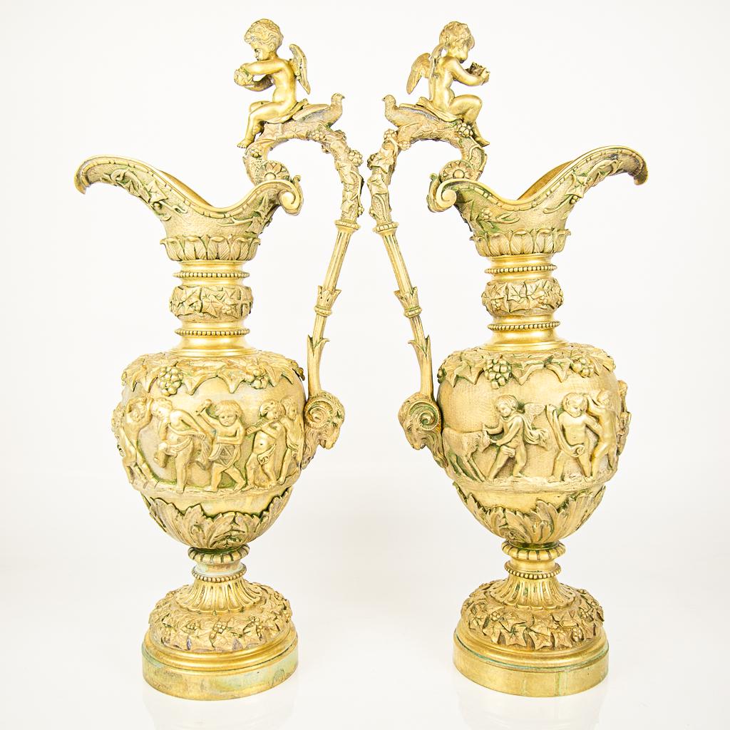 Pair Large Ornate Bronze Dore Ewers: Large pair of lemon gilt bronze decorative objects in the form of ewers, after Piat Joseph Sauvage (Flemish, 1743-1818) the "Triumph of Dionysus." Cast with grapevine and acanthus leaf design. [22 1/2