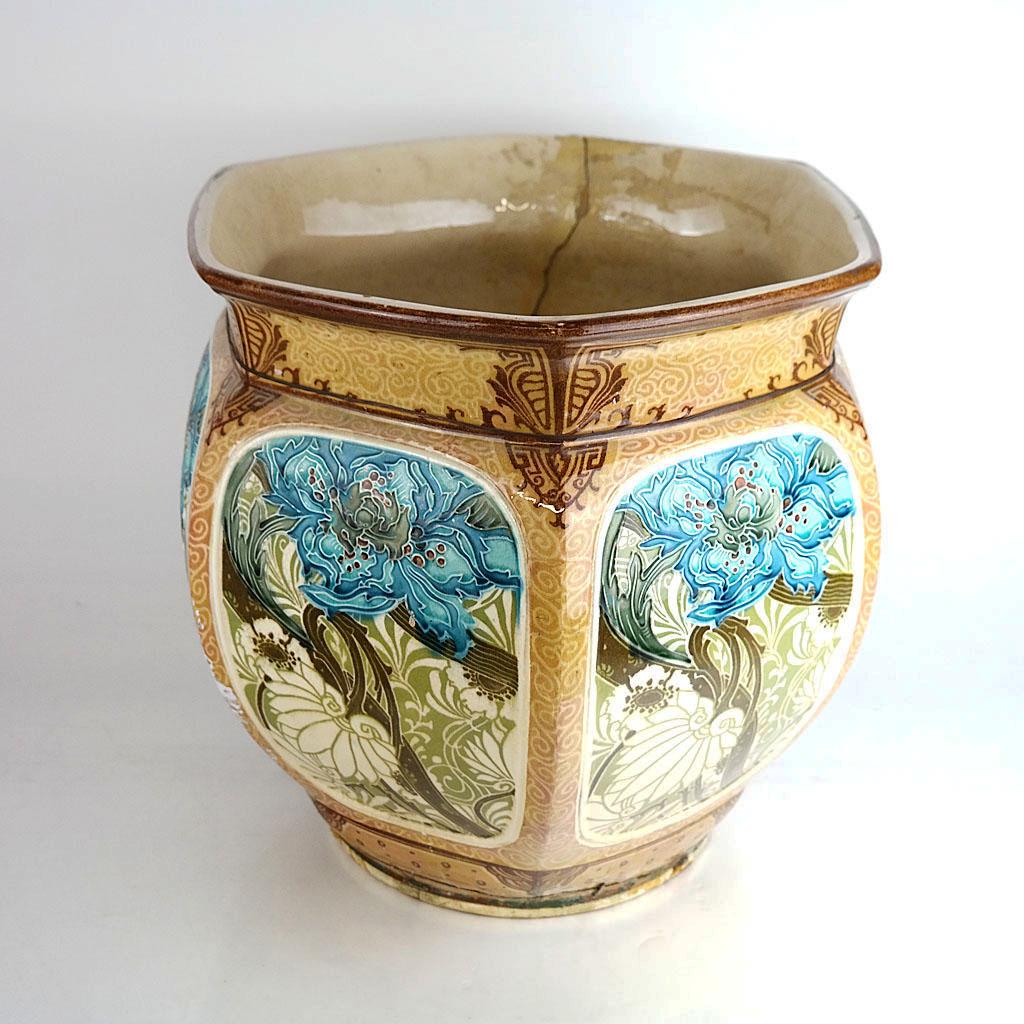 Minton Secessionist Jardiniere: Minton enamel and slip-decorated jardiniere, decorated in stylized floral and foliate designs. [14 1/2" H x 15 1/2" Diam.]. Wired; glaze losses; stapled; cracked and restored.