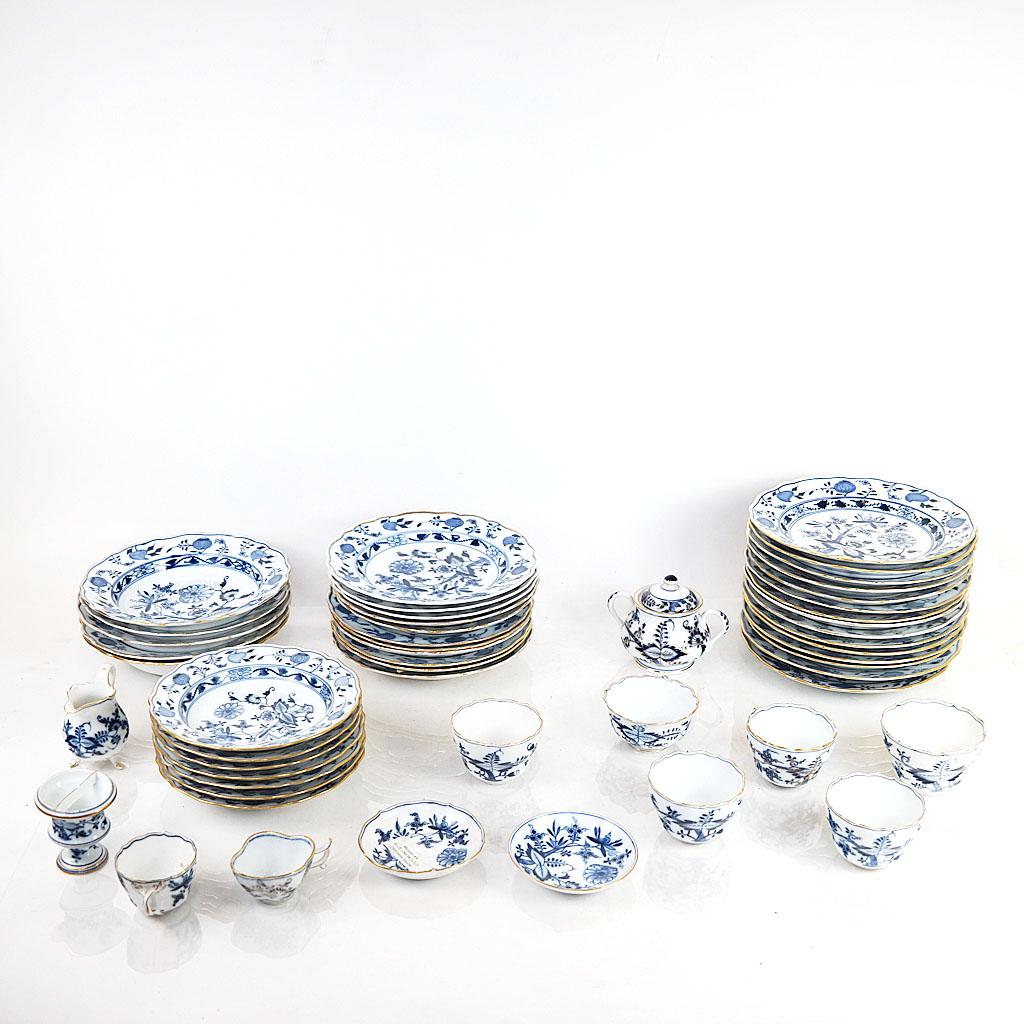 Meissen Porcelain "Blue Onion" Group: Meissen German gilt-accented porcelain "Blue Onion" group, 19th and 20th century, comprising plates, shallow bowls, dishes, cups, creamer and sugar bowl, the assembled group with various date marks to