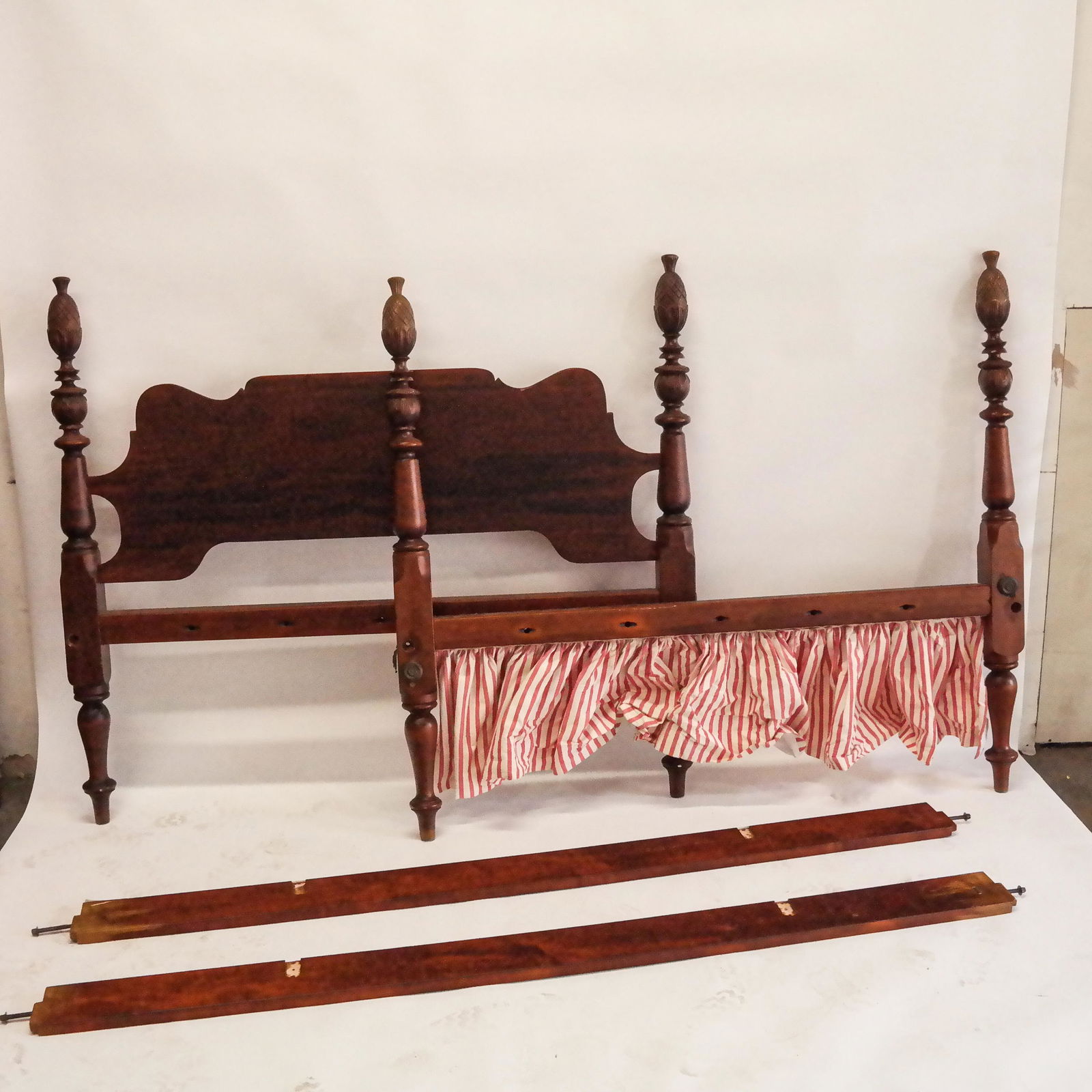 Colonial Revival Carved Mahogany Bed: Colonial Revival carved mahogany bed, 20th century, in the Caribbean taste, with four pineapple motif finials. [55 1/2" H x 63" W x 88" L; Rails: 82" L]. Fading, scuffs, wear and losses.
