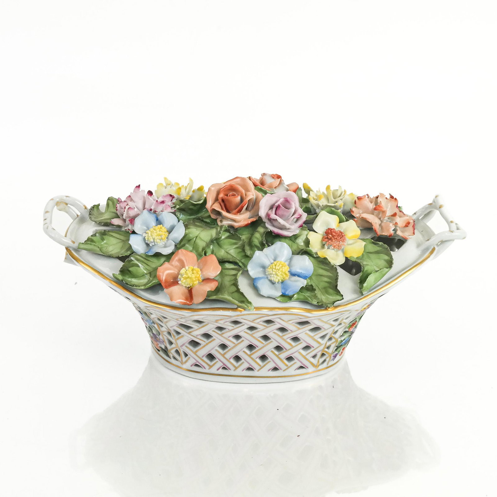 Herend Hungarian Painted Porcelain Sculpture: Herend Hungarian painted porcelain sculpture, 20th century, modeled as a reticulated basket of flowers, marked to base. [5" H x 11 1/4" W x 7" D]. Tiny losses to flowers; wear to decoration.
