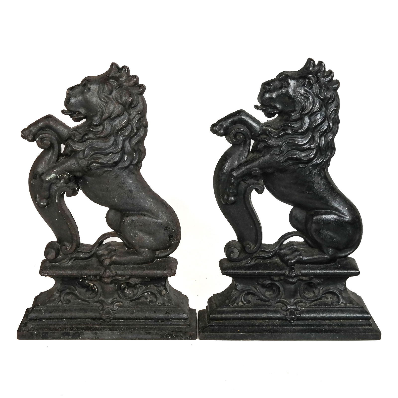 Pair of Victorian Cast Iron Doorstops: Pair of Victorian cast iron doorstops, late 19th century, each with heraldic lion sejant erect with scrolling shield on stepped plinth base. [15" H x 10" W x 2 3/4" D]. Oxidation, residue and wear.