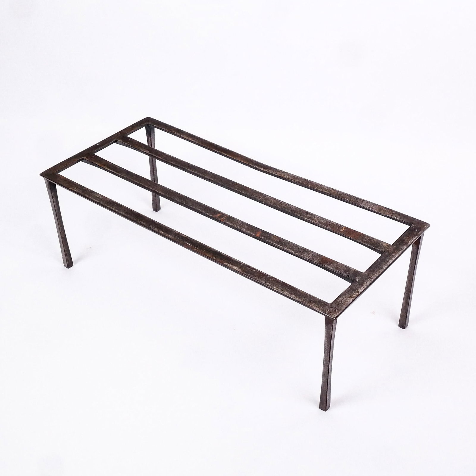 Wrought Iron Fireplace Log Butler: Wrought iron fireplace log butler, the stand going nicely beside a hearth. [9" H x 26 3/4" W x 2" D]. Marks, oxidation and wear.