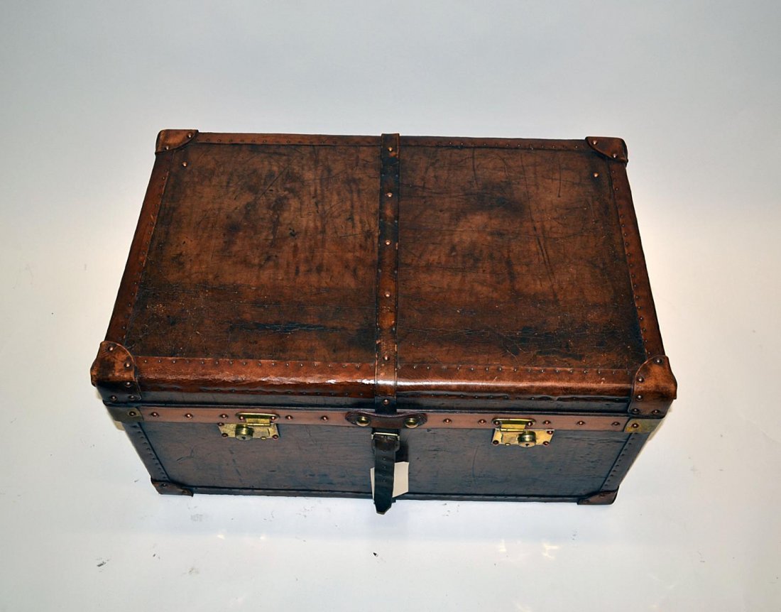 Brown Leather Trunk: Brown leather trunk, having a burgundy upholstered interior. Worn. 32" L x 20" D x 16 1/2" H.