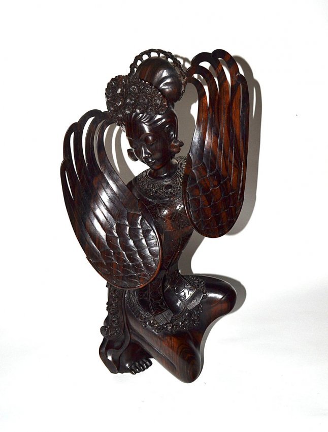 Balinese Rosewood Figure: Sculpture of a female Balinese ceremonial dancer, holding two wings in a kneeling position, stamped MD Midermas Bali. 19" H. Good condition.