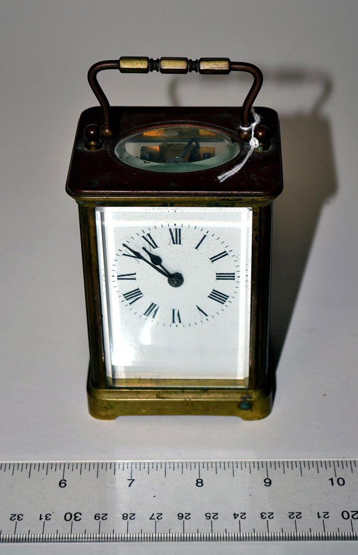 Carriage Clock: Bronze case, white face with key, initialed on back: "F.L." 4 1/4" x 3" [approx].