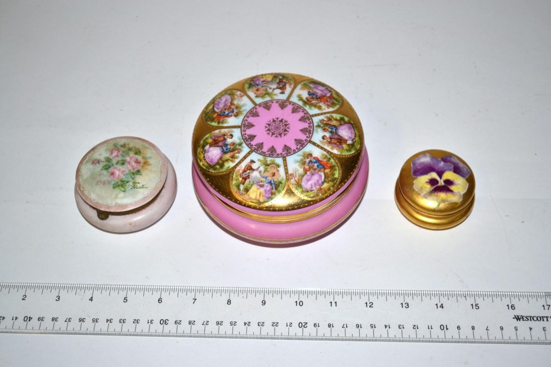 Three Continental Porcelain Boxes: Comprises a French box with bronze fittings and floral décor, German box with courting scenes on lid, and a French box with rose décor. Largest: 3" H x 5 1/2" Dia. In good condition.
