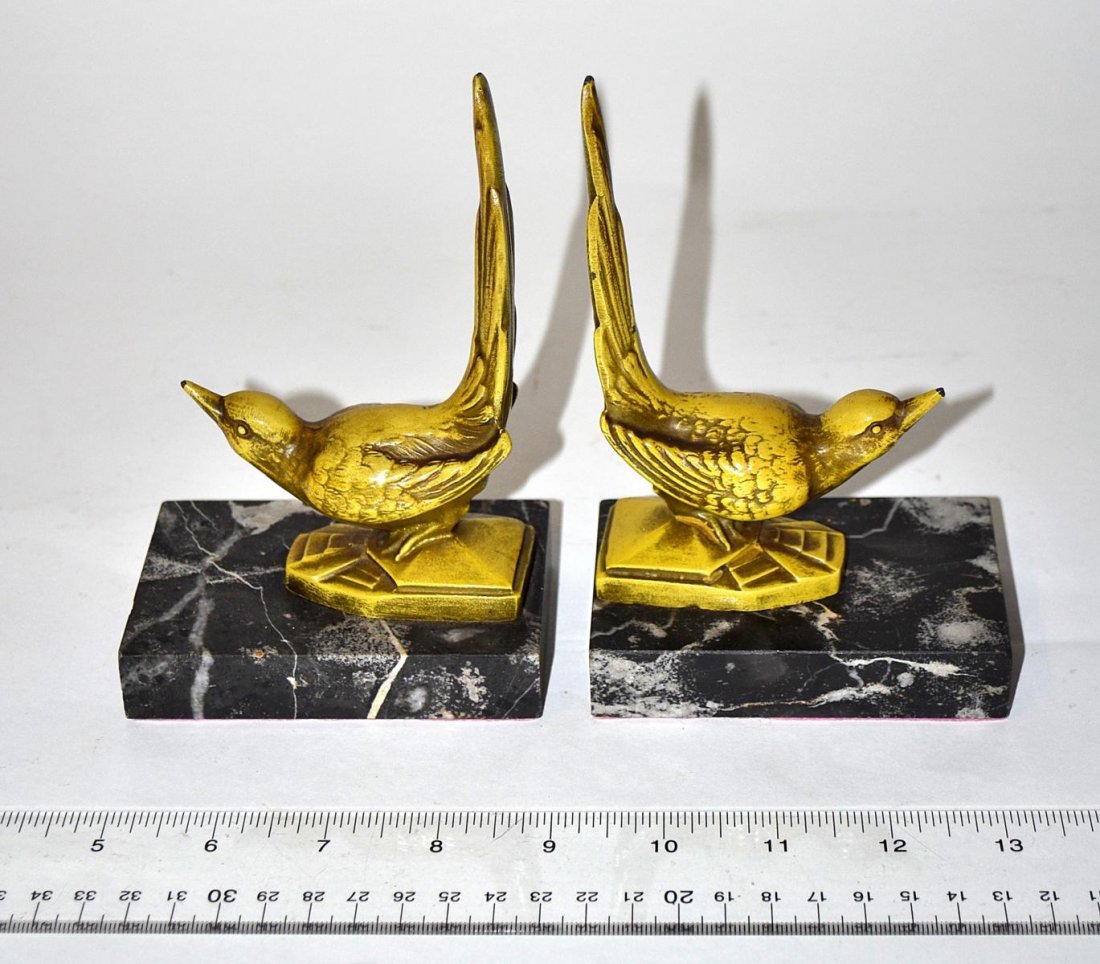 Pair of Art Deco Cold Painted Bronze Bookends: Bird-form bookends with exaggerated tail feathers. Both mounted on rectangular marble bases. Each 3 7/8" W x 2 5/8" D x 6" H. Some chips and losses to paint, otherwise in good condition.