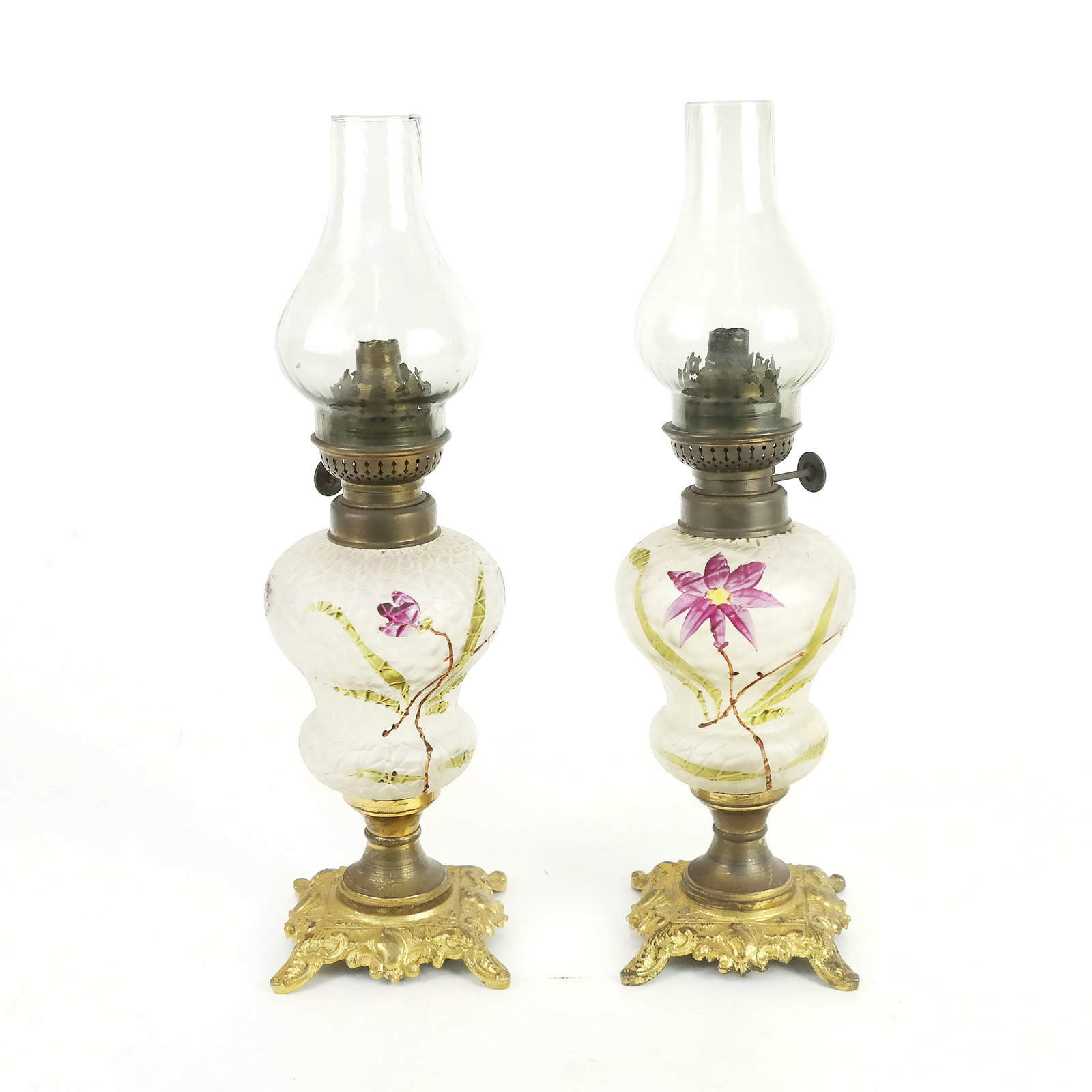Pair of Victorian Glass & Gilt Metal Oil Lamps: Pair of Victorian glass and gilt metal oil lamps, late 19th century, having boudoir lights with painted floral decoration. Shades possibly later.