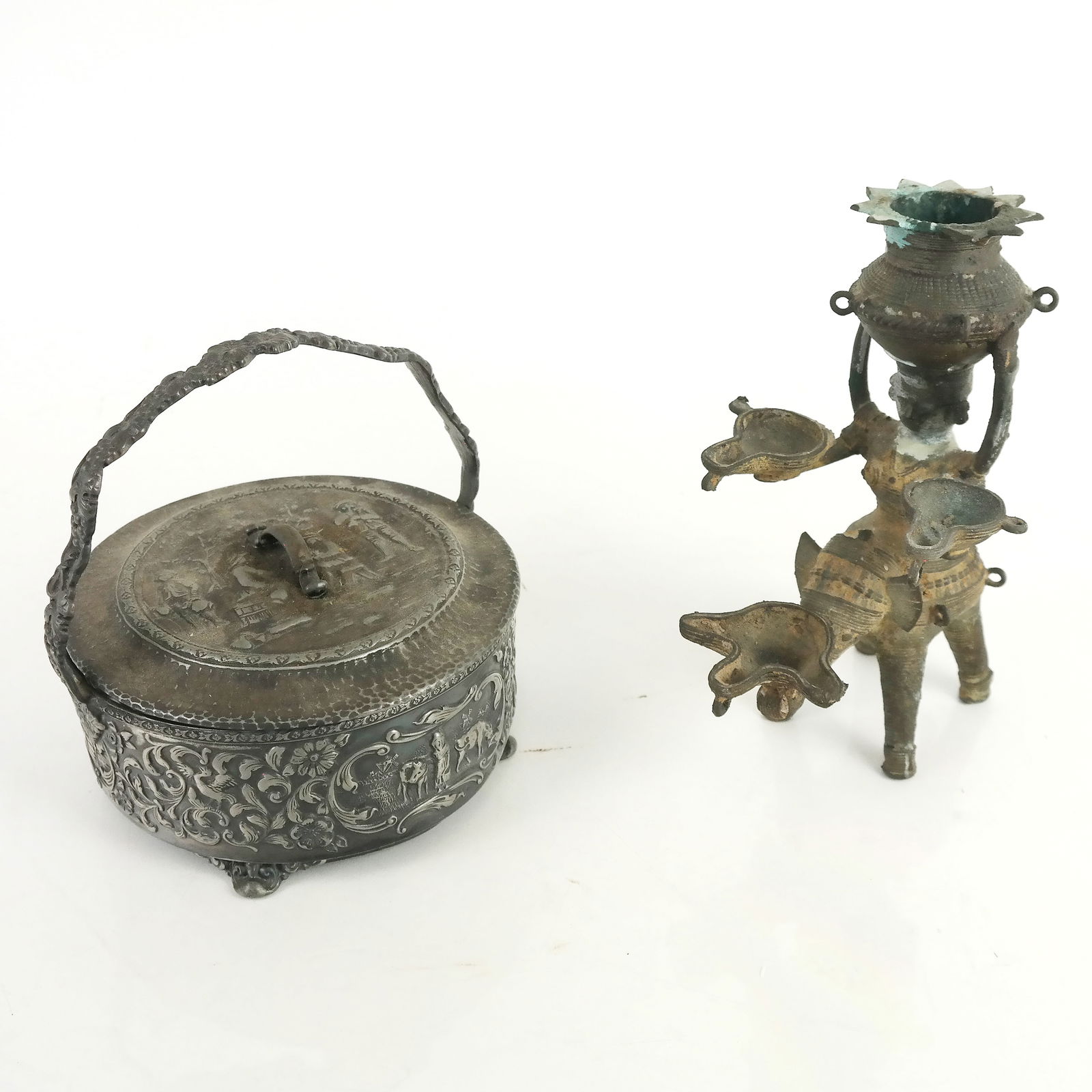Two Metal Decorative Objects: Two metal decorative objects, including an Indian figural candlestick and a Southwest Asian storage basket. [Taller: 7" H x 6 1/2" Diam.]. Residue and oxidation.
