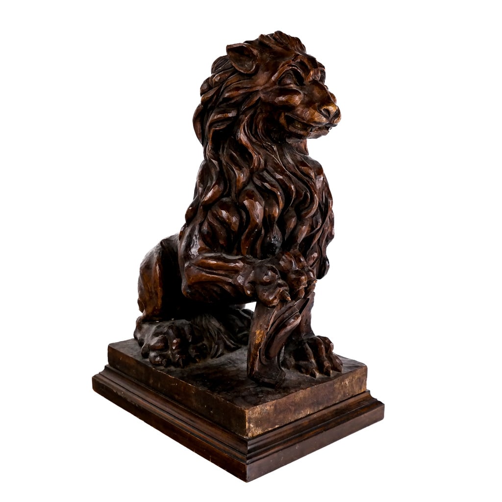 Heraldic Carved Oak Sculpture of a Lion: Carved oak sculpture depicting a seated lion holding a shield, on associated plinth base. [21 1/2 x 15 1/2 x 11 inches]. Cracks and losses.