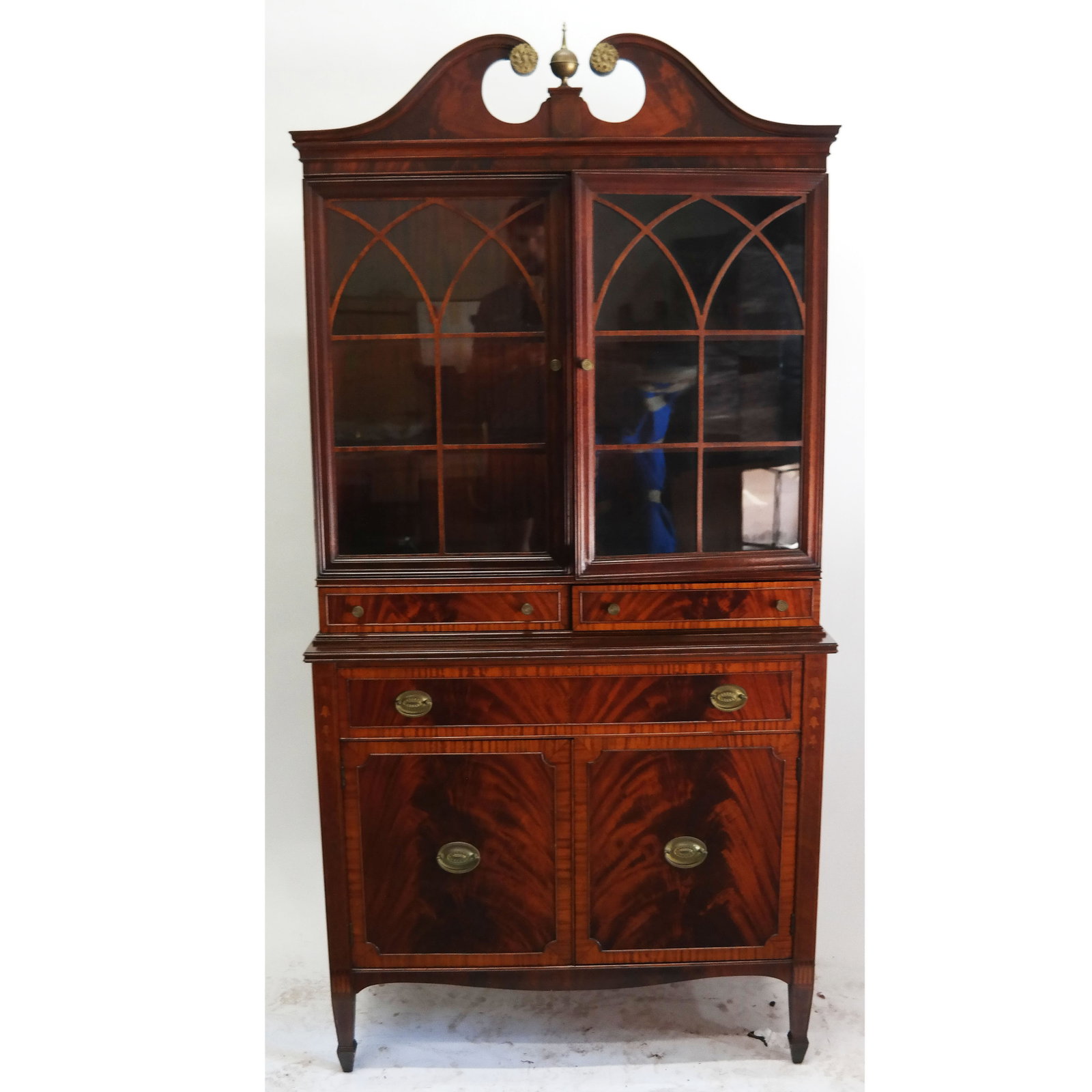 Antique American Federal-Style Inlaid Mahogany Cabinet: American Federal-style inlaid mahogany cabinet, 20th century, having a broken swan neck pediment over glazed doors, the lower section with brass hardware to the drawers and cupboard doors. [78" H x 38