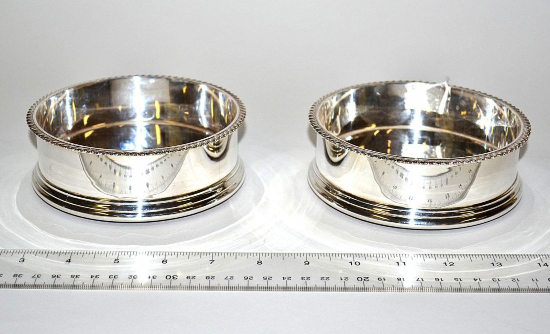 Pair of Asprey Sterling Silver Bottle Coasters: Both stamped with hallmarks and "Asprey/Sterling England." Each 5 1/4" Dia x 1 7/8" H.