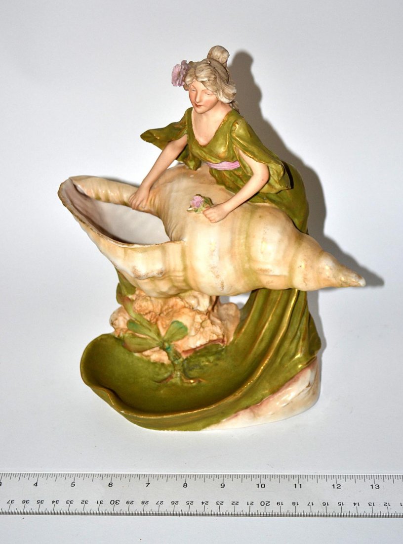 Royal Dux Figure, German: German porcelain sculpture of a woman and conch shell. Some losses. 10" x 10".