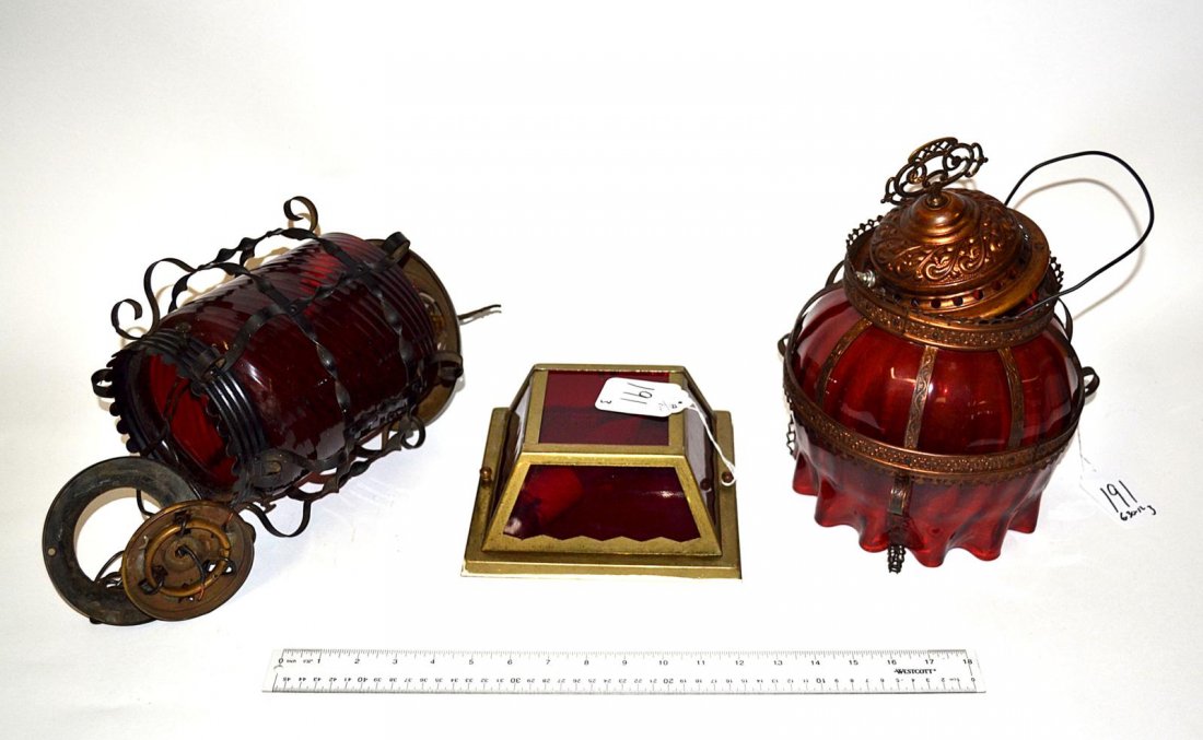 Three Ruby Glass Lights: One ceiling fixture together with two Victorian style lantern form fixtures, all having brass frames.