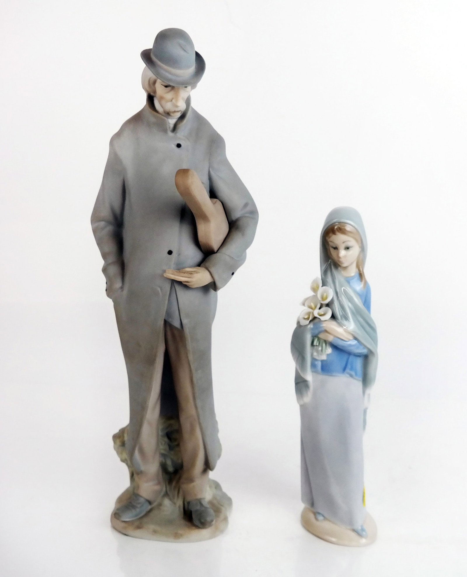 Two Lladro Spanish Porcelain Figures: Two Lladro porcelain figures, comprising "Old Man With Violin" (#4622) and "Girl With Flowers" (#4650). [Taller: 13 1/2" H x 4 3/4" Diam.]. Minor wear.