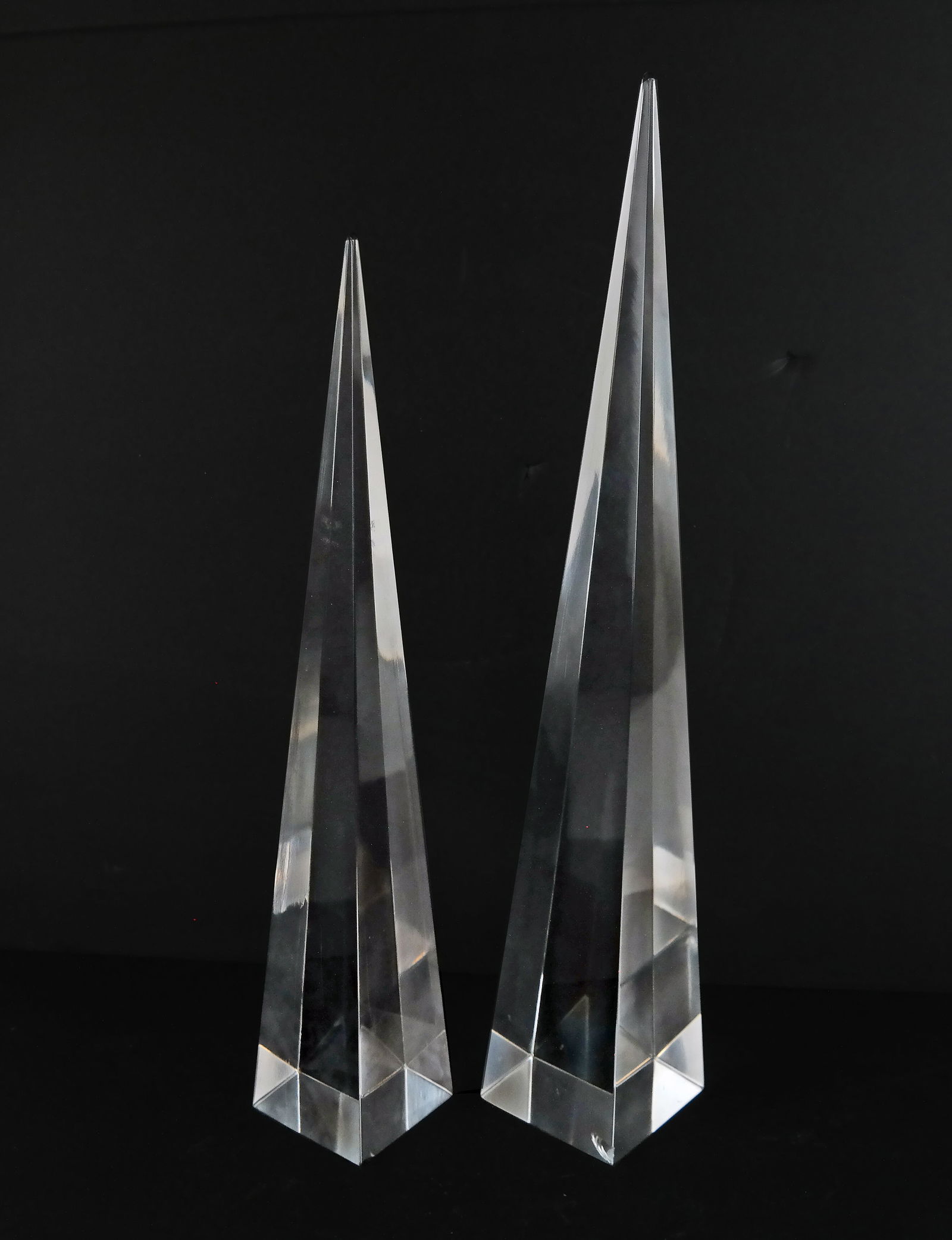 Set of Two Glass Obelisks: Set of two glass obelisks. [17" H and 20" H]. Each with a chip on base.
