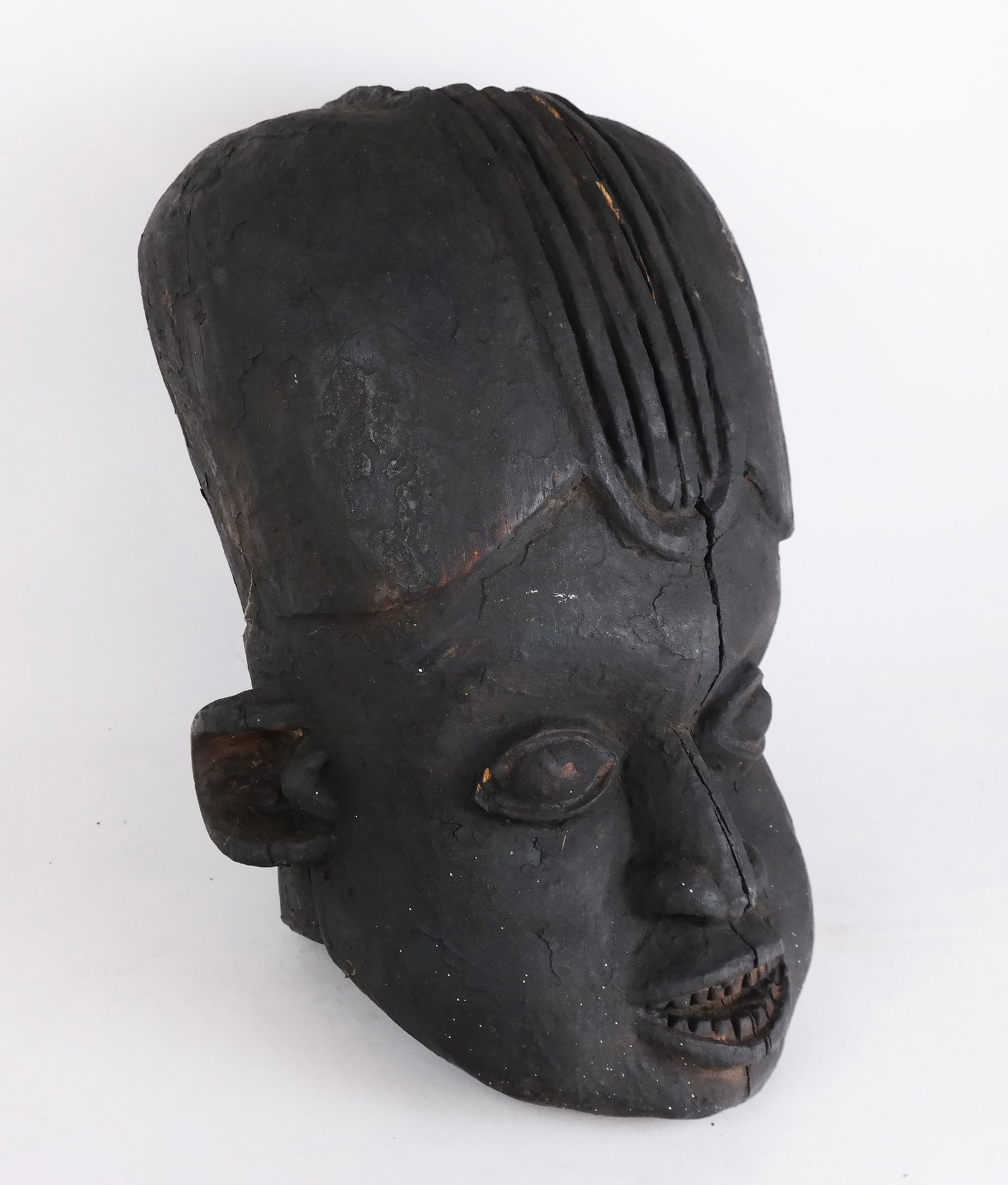 African Carved Wood Tribal Mask: African carved wood tribal mask. [16 1/2 x 8 3/4 x 9 1/4 inches]. Full-length age crack and other small cracks, accretion, residue.