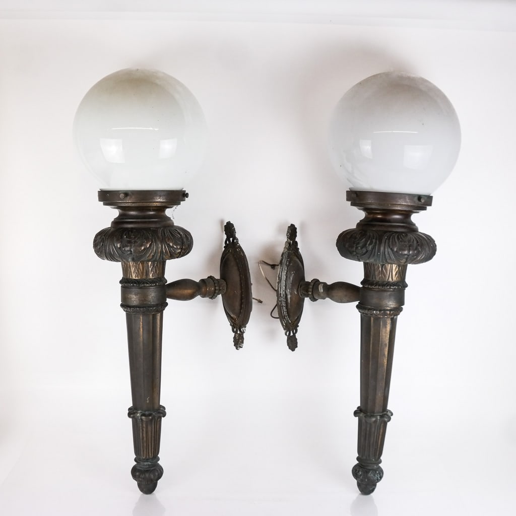 Belle Epoque-Style Pair of Bronze Sconces: Of generous proportions, modeled as torches with acanthus leaf details. [25 x 8 x 13 inches]. Scattered spots and marks, light oxidation and residue.
