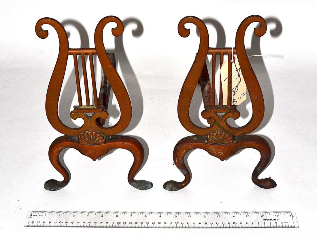 Pair of Bronze Lyre-Form Andirons: Each with shell accent and pad feet. 8 1/2" W x 16 1/4" D x 13 1/4" H. In good condition.