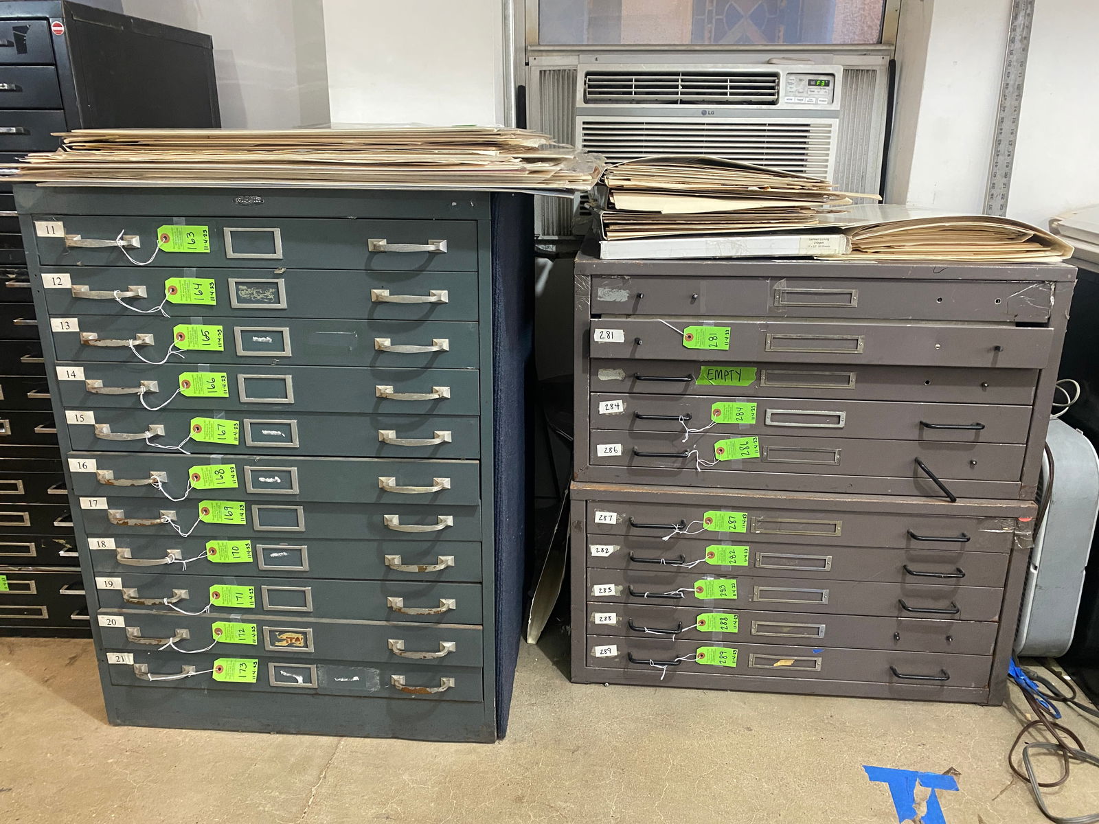 Group of Grey Metal Flat File Cabinets: Group of approximately 6 grey metal flat file cabinets, in various sizes, including a pair of five-drawer cabinets with black pulls (many drawers missing handles), a tall 11-drawer cabinet with metal